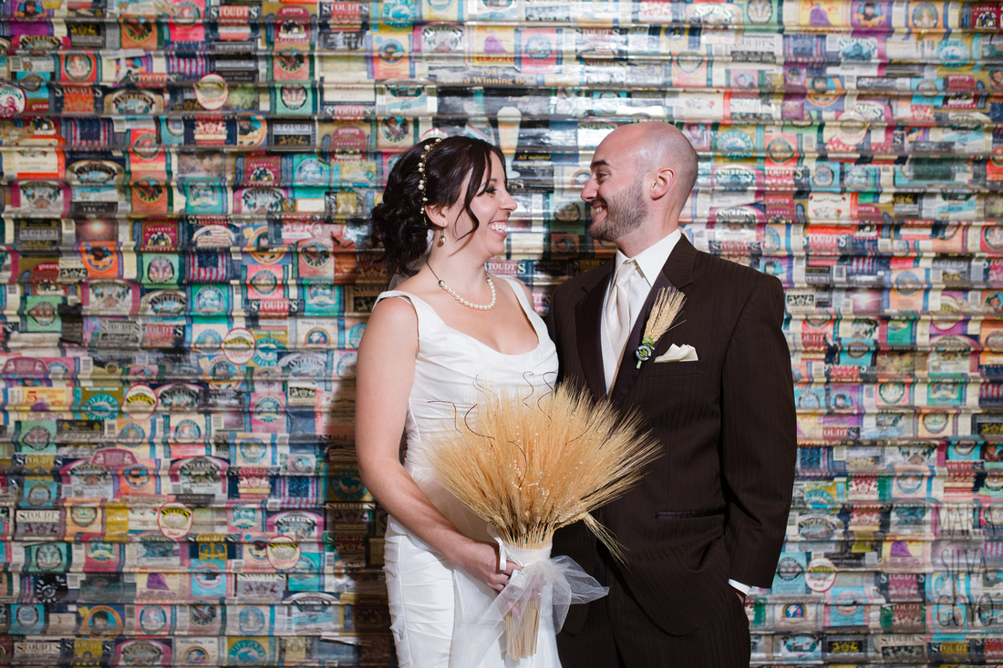 Bride and groom by the beer labels wall at Stoudt's