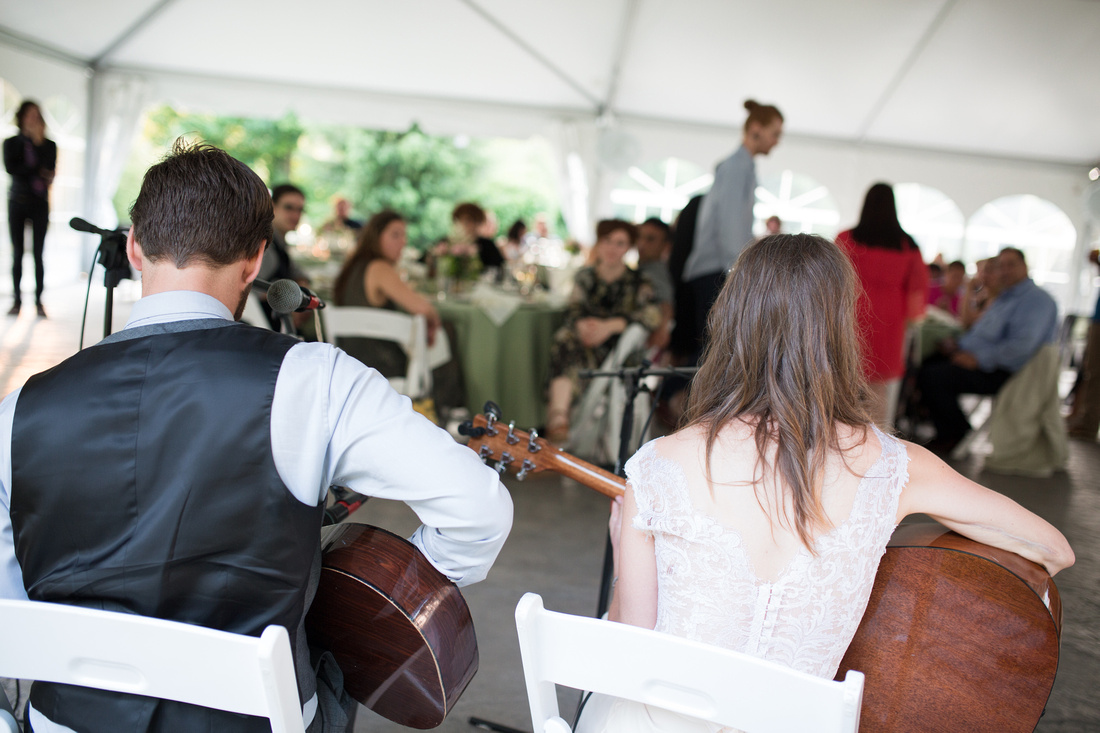 Bride and groom playing guitar during their reception