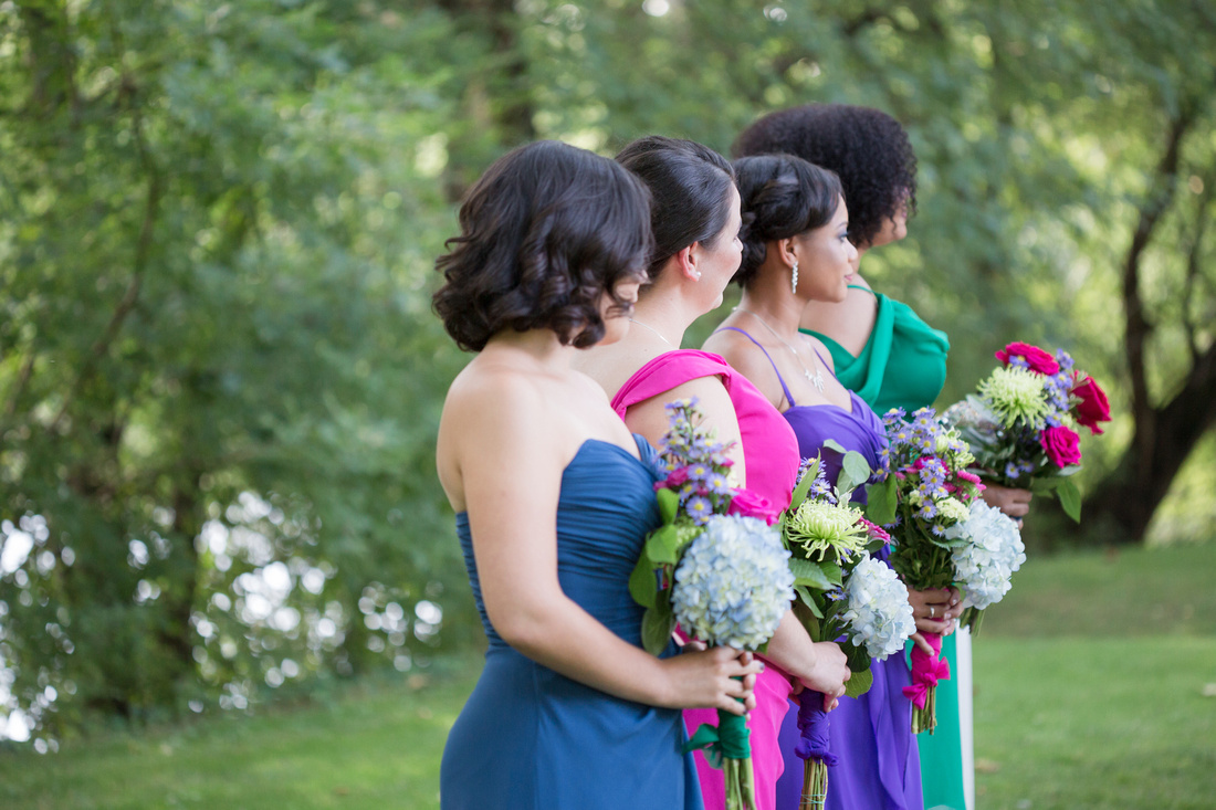 Colorful Bridesmaids during ceremony at Riverdale Manor