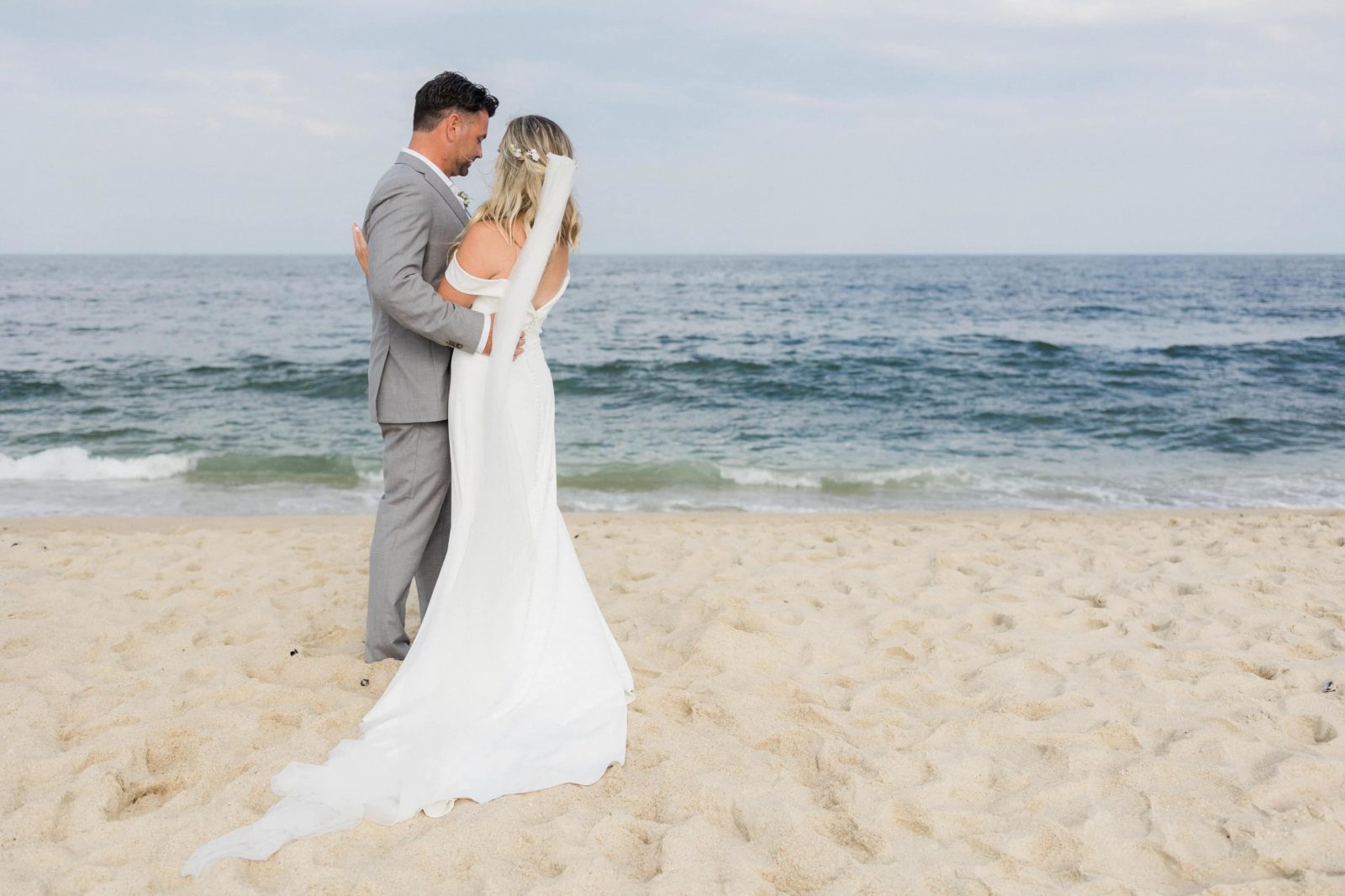 Bride and groom portrait at the beach in front of the Belmar Taylor Pavilion
