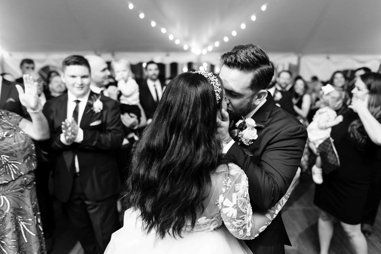 black and white photo of groom kissing the bride at the end of their first dance