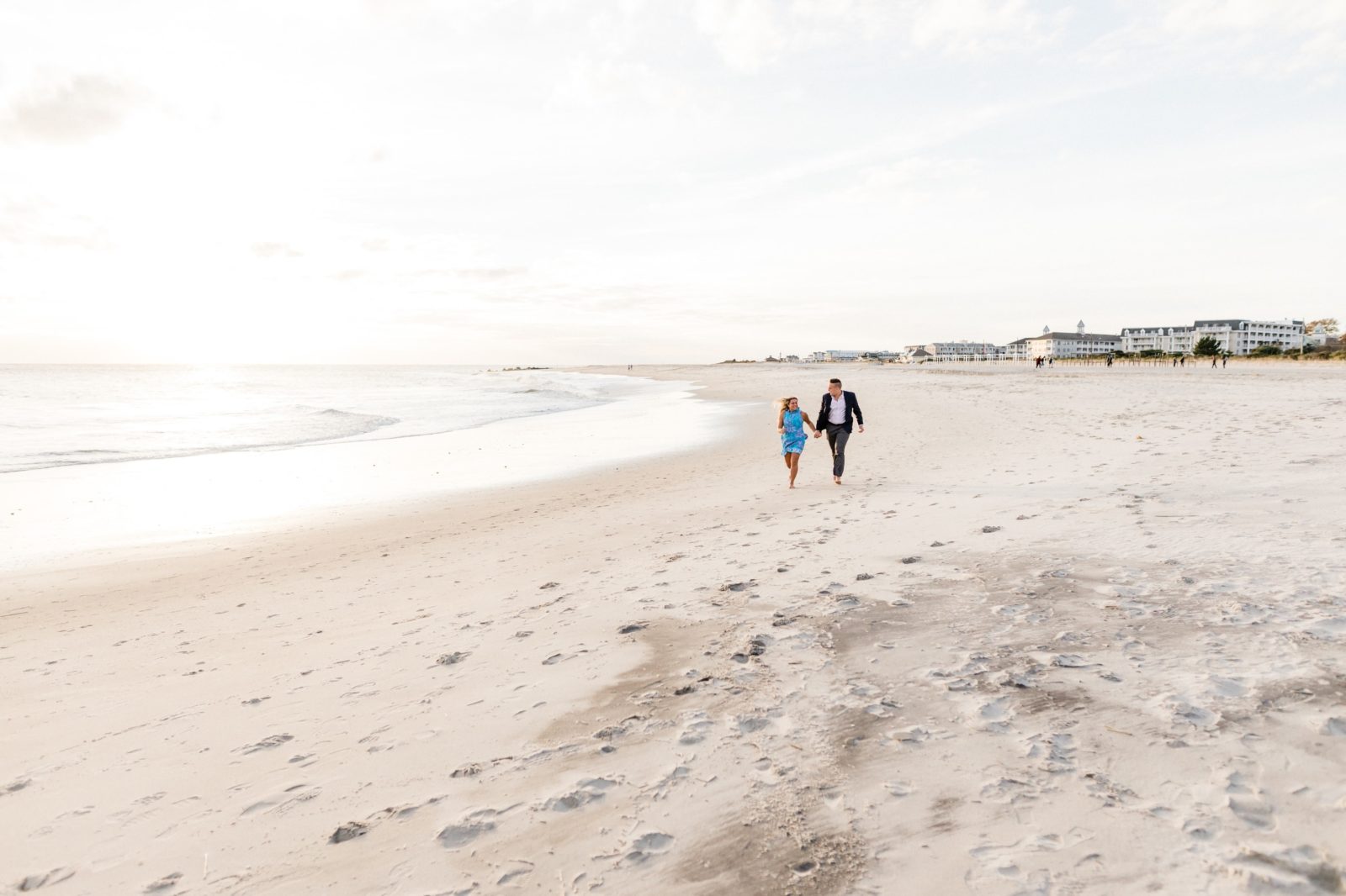 Couple running on the beach in Cape May at sunset