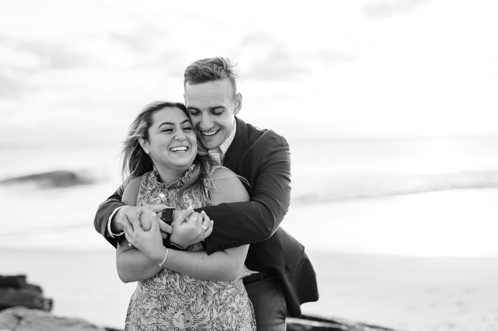 Black and white photos of couple hugging and laughing in Cape May