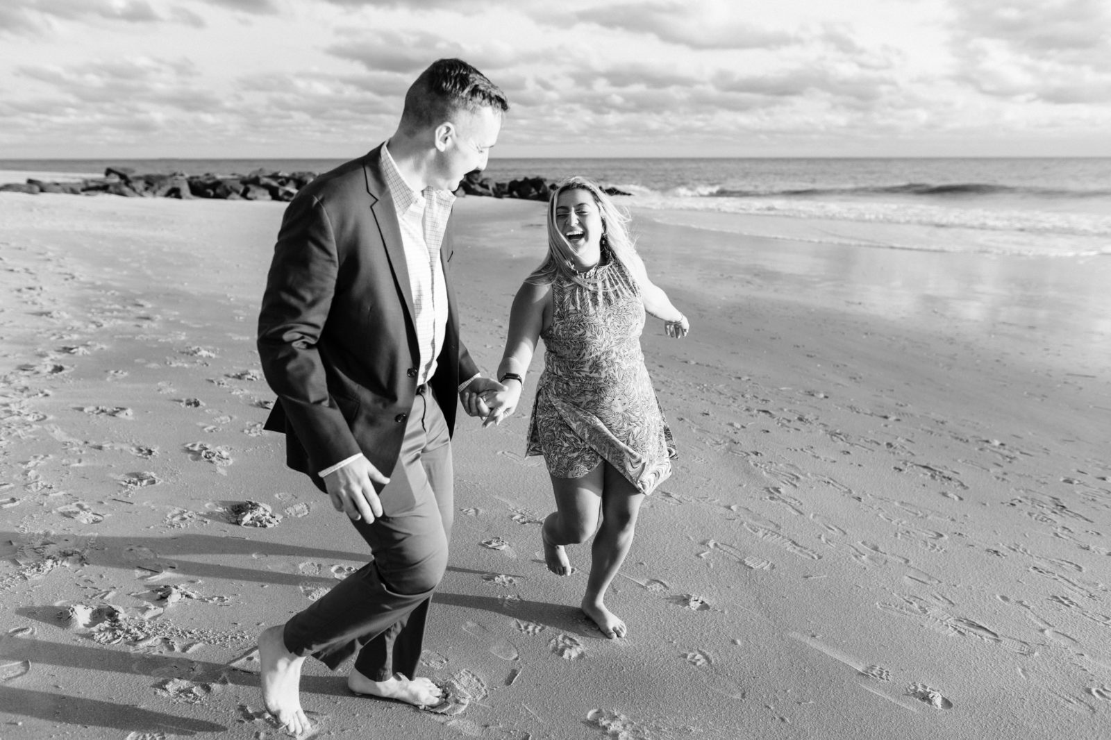 Black and white photos of couple running and laughing in Cape May