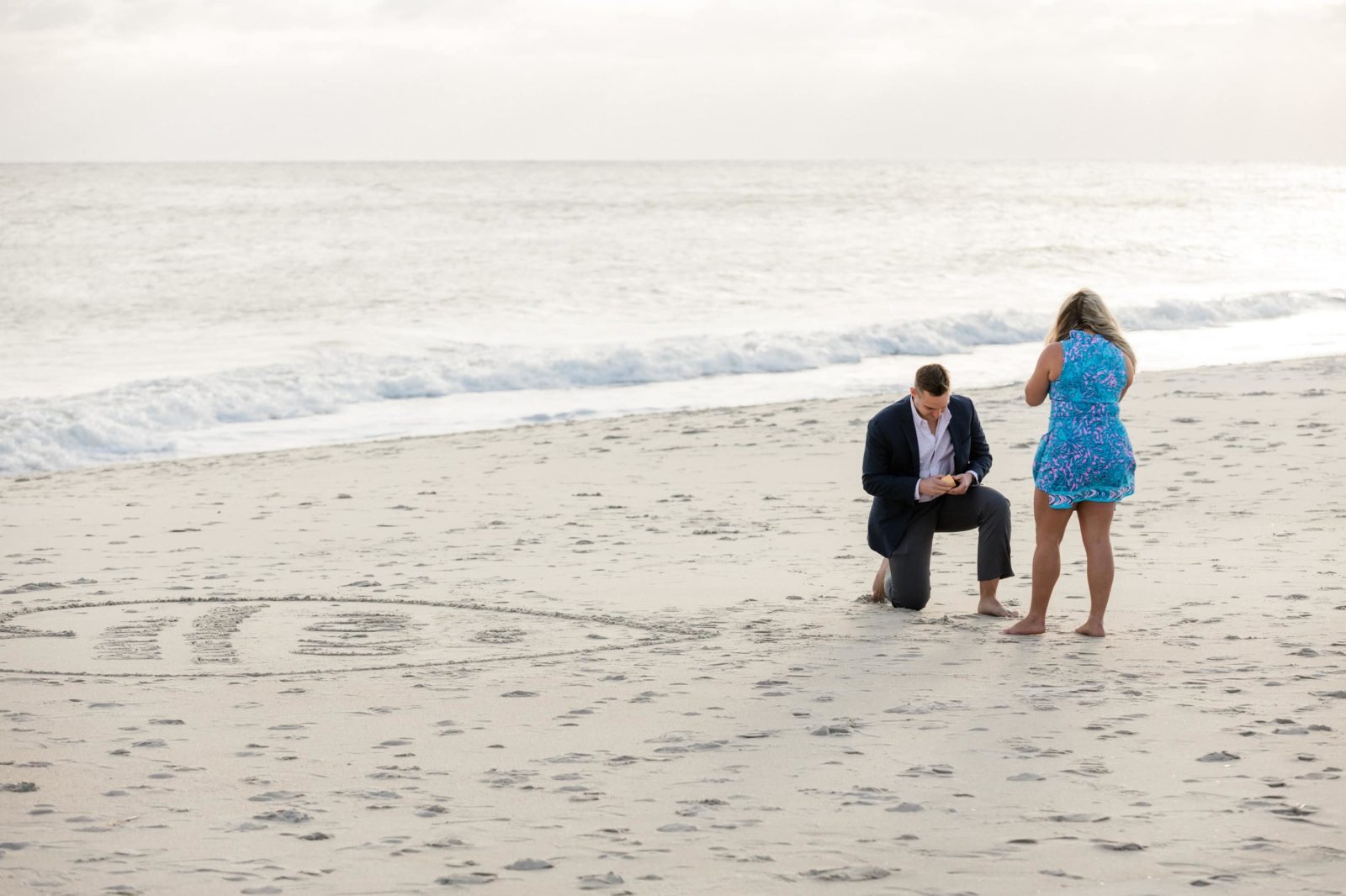 Guy getting the ring out of his jacket during secret beach proposal