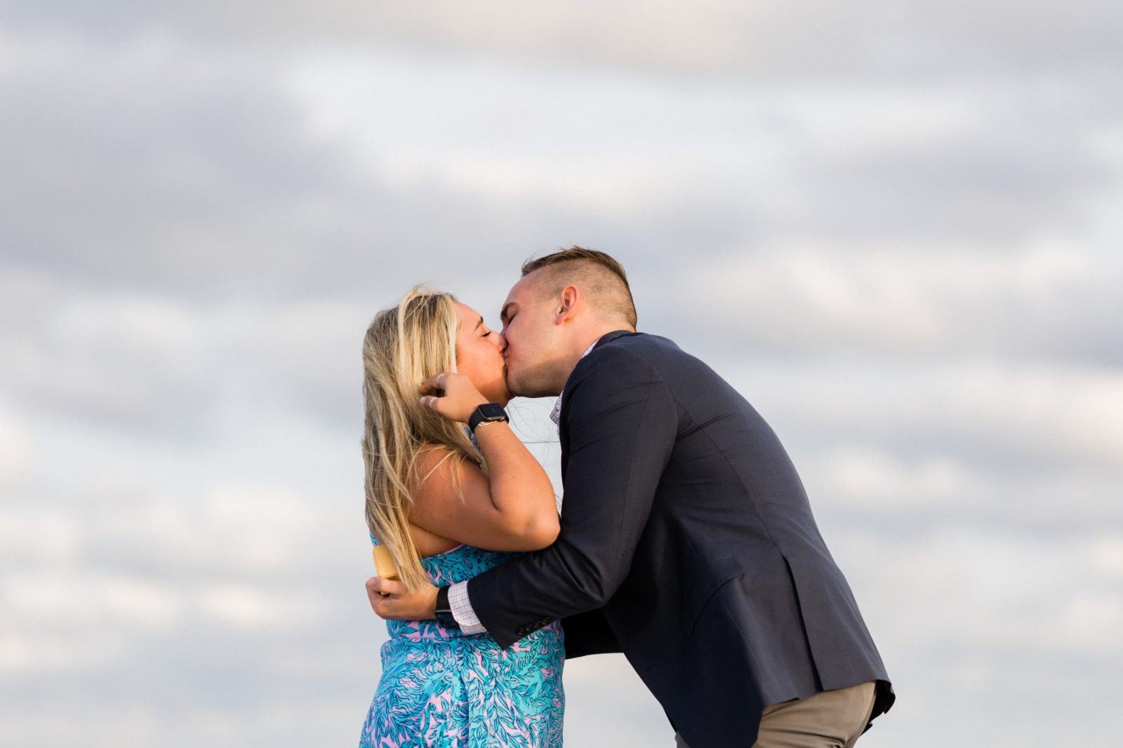 Couple kissing during emotional beach proposal in Cape May