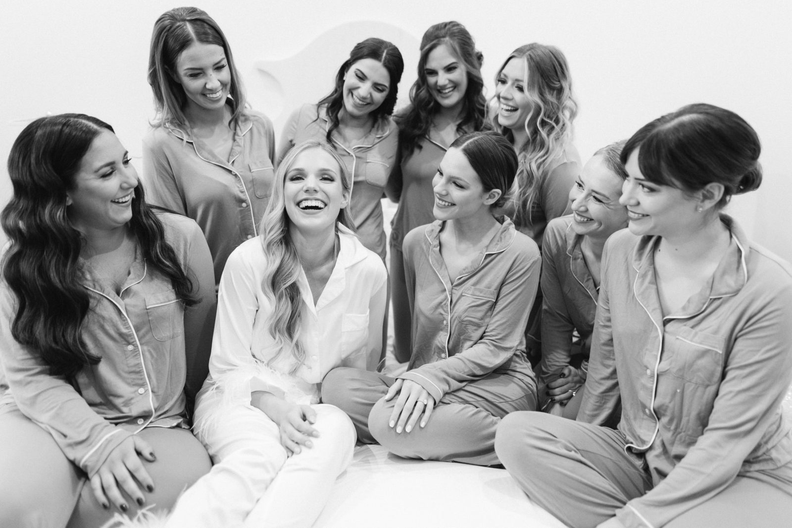 Bride laughing surrounded by her bridesmaids in matching PJs