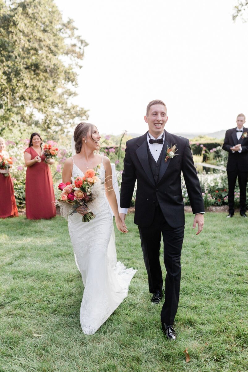 Bride and groom smiling as they walk away at the end of their garden ceremony at Box Hill Mansion, photographed by Maria Silva-Goyo Photography