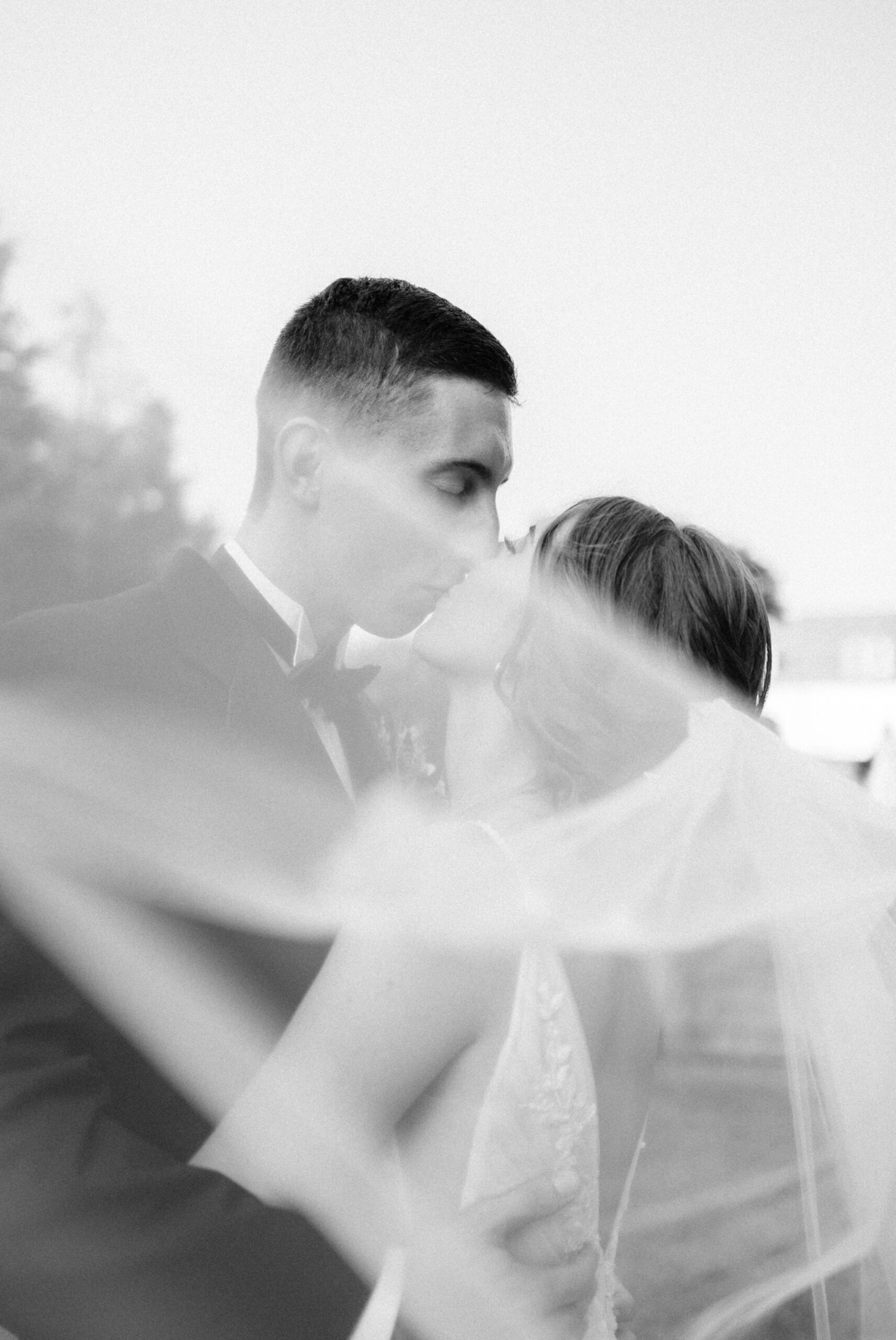 Black and white photo of bride and groom kissing behind the veil at Box Hill Mansion, photographed by Maria Silva-Goyo Photography