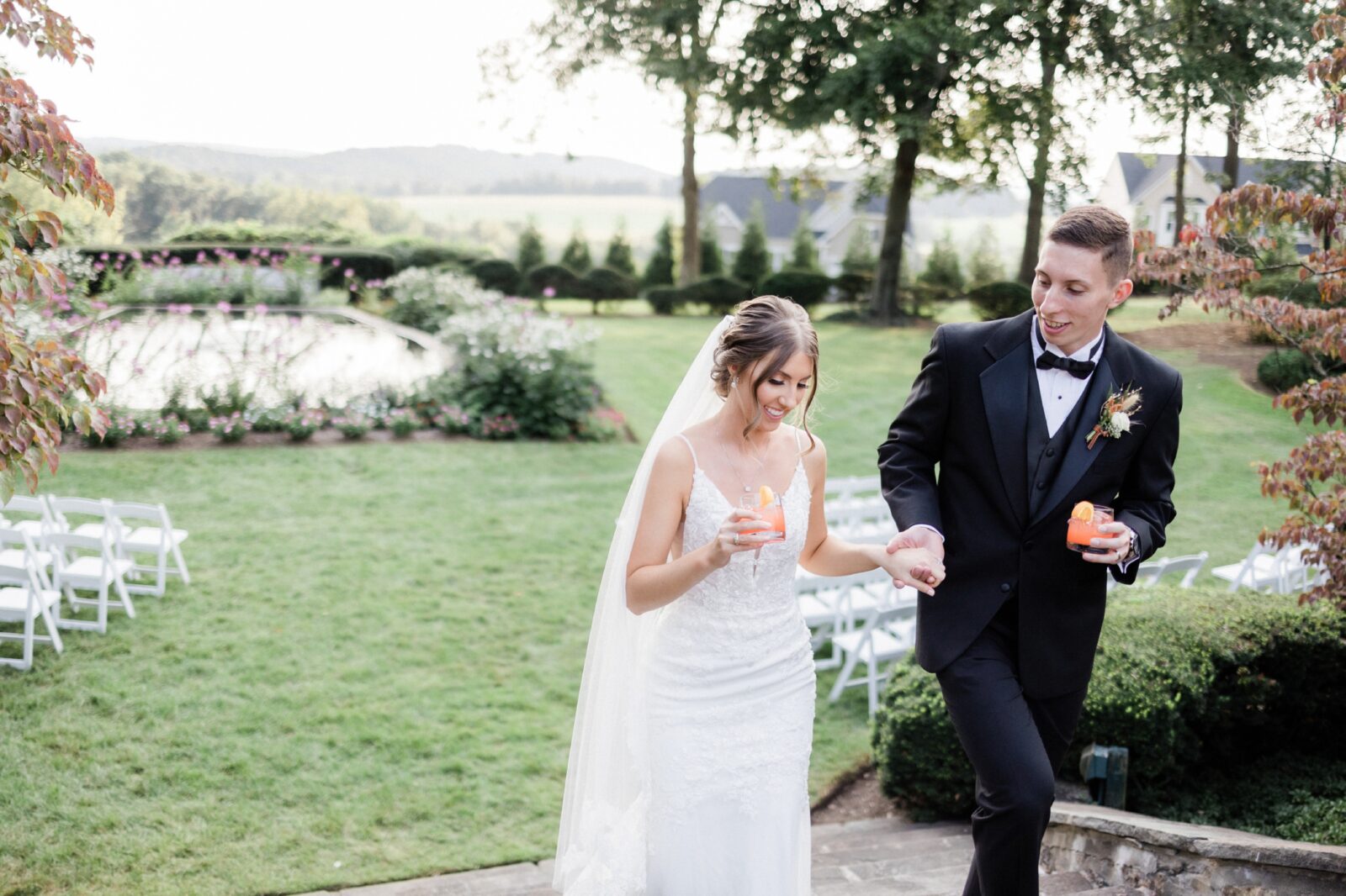 Bride and groom walking with their signature drinks 