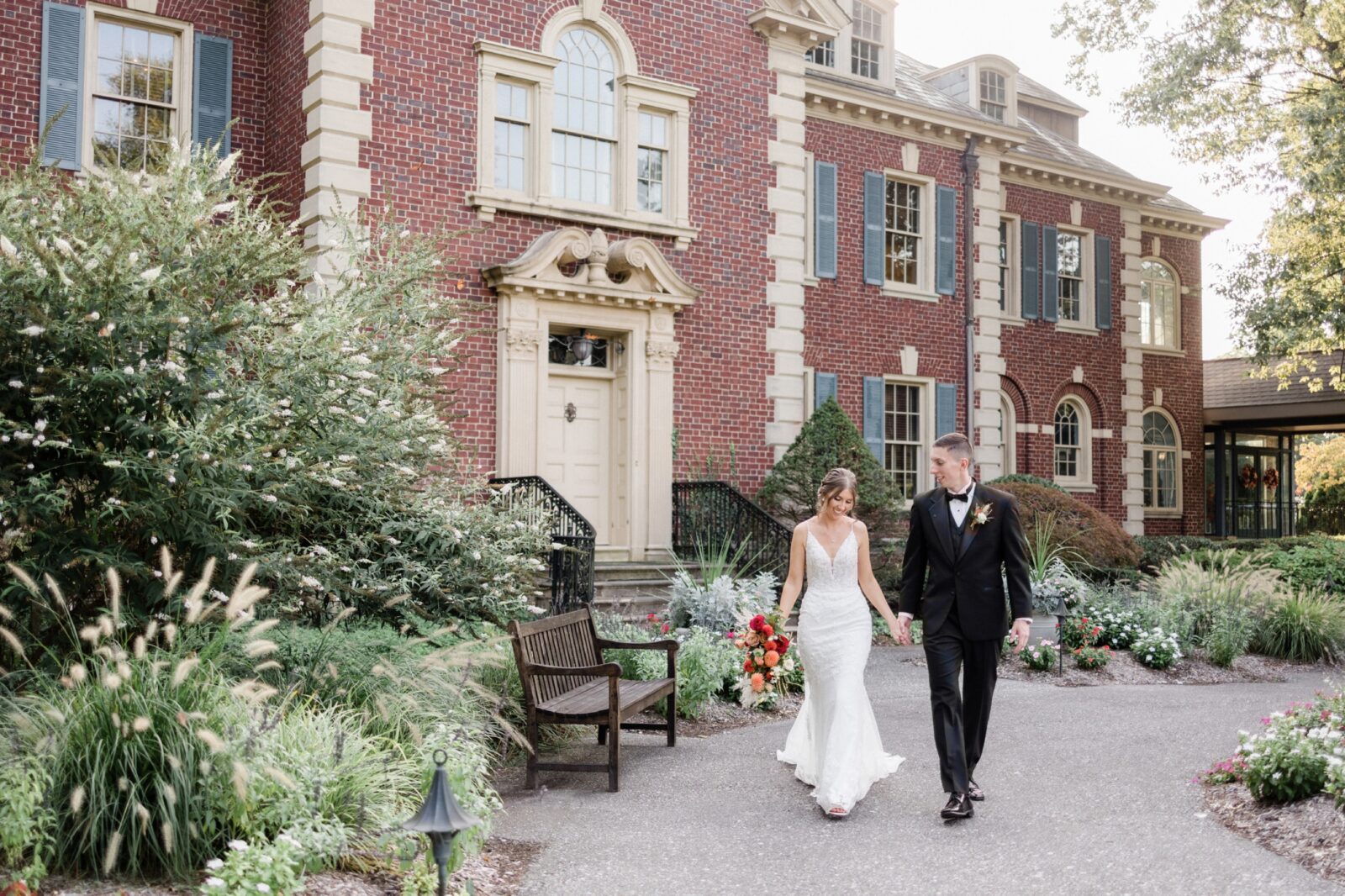 Bride and groom walking on the path behind the mansion - Box Hill Mansion wedding