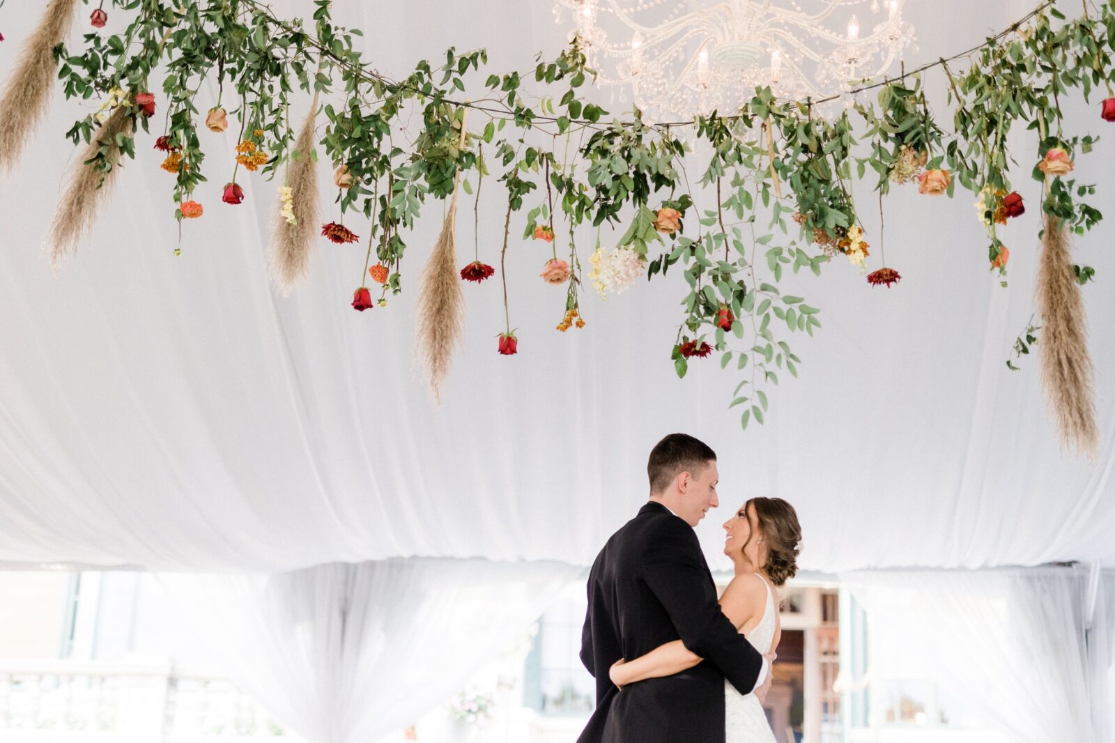 Bride and groom's first dance under the hanging flower arrangement at Box Hill Mansion photographed by Maria Silva Goyo
