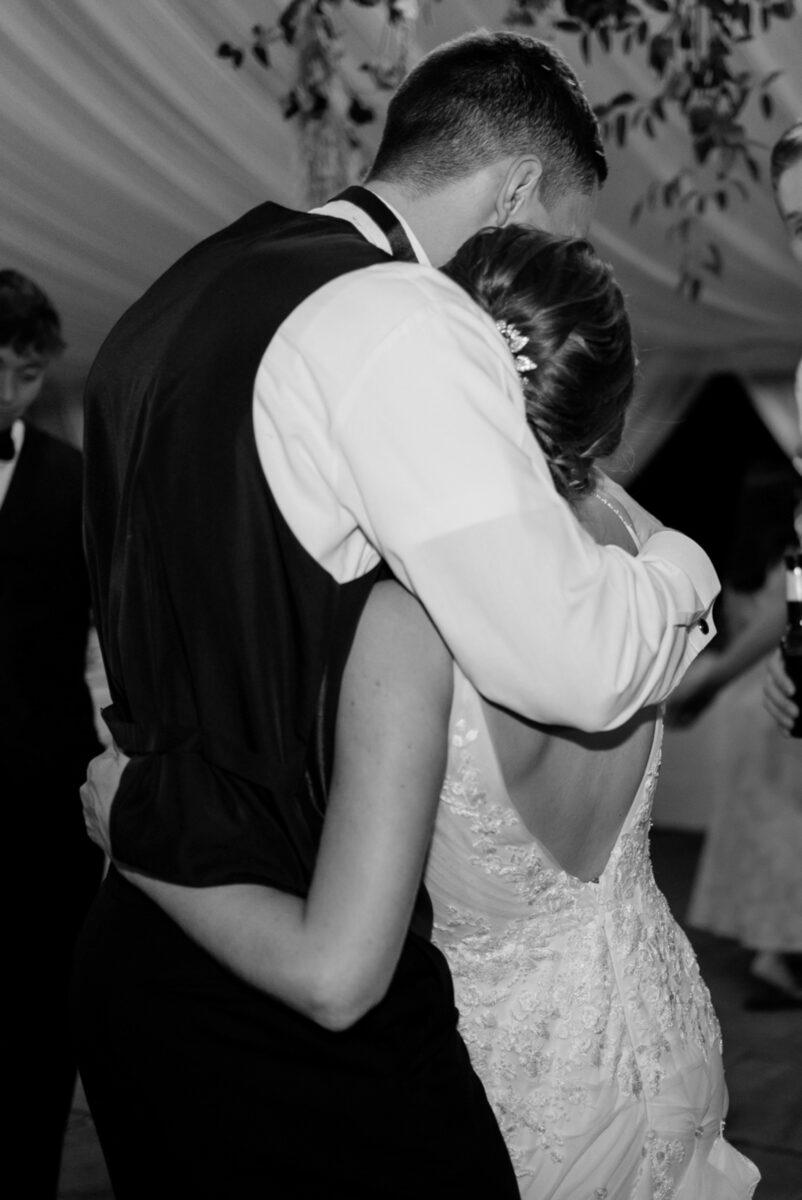 Candid photo of bride and groom hugging during the reception