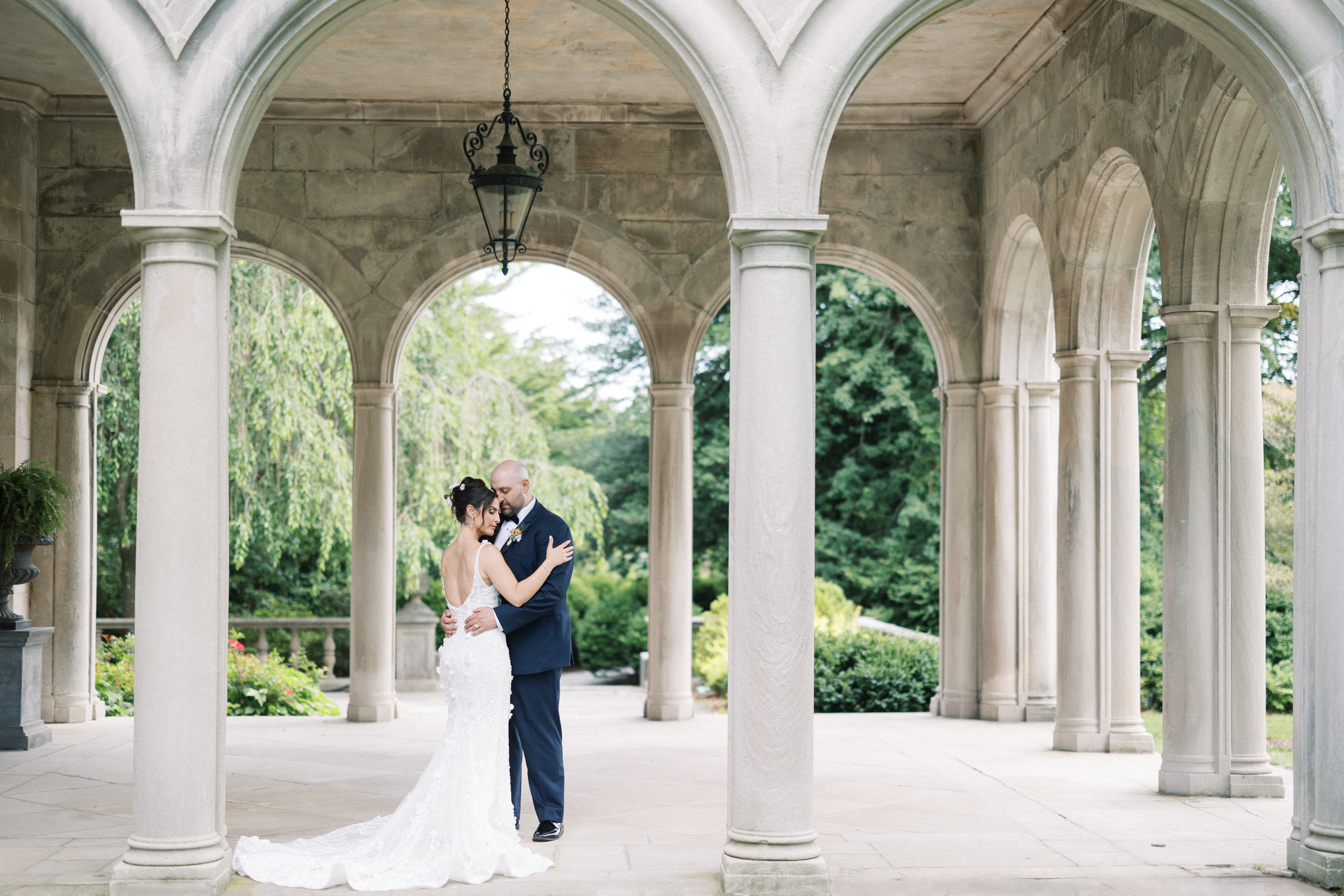 Bride wearing Blanche dress with groom wearing navy tuxedo, at the Planting Fields Arboretum in Long Island